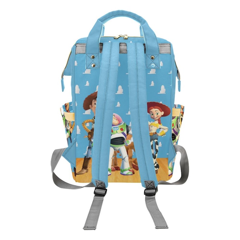 May include: A light blue backpack featuring characters from the Toy Story movie. The backpack has a light blue background with white clouds. The backpack has two side pockets and adjustable shoulder straps.