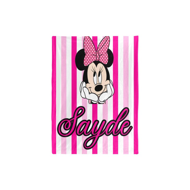 May include: A pink and white striped blanket featuring Minnie Mouse with a pink polka dot bow. The blanket has the name "Sayde" in a cursive font. The blanket is a vibrant and colorful item.