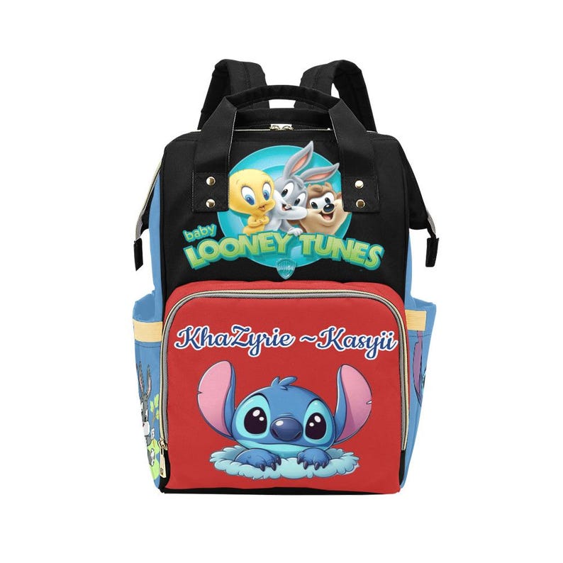 May include: A black backpack featuring a Baby Looney Tunes graphic with Tweety, Bugs Bunny, and Taz at the top. The front red pocket displays the name KhaZyrie ~ Kasyii above a blue Stitch character graphic. The bag has black straps and blue sides.