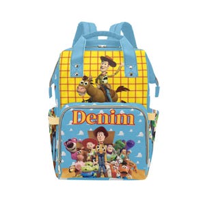 May include: A blue and yellow backpack featuring characters from the Toy Story movie. The backpack has a large front pocket with the word "Denim" printed on it. The top section has a yellow plaid pattern with a cartoon image of Woody riding a horse.