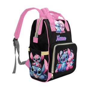 May include: A black backpack with pink trim and straps featuring cartoon characters Stitch and Angel. The front pocket and side display colorful illustrations of the characters with floral accents. The word Name is printed in blue and pink on the front.