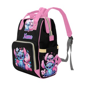 May include: A black backpack with pink trim, straps, and handles. The front features cartoon characters Stitch and Angel, floral accents, and the word Name in blue and pink script. The side pocket also displays the characters Stitch and Angel.
