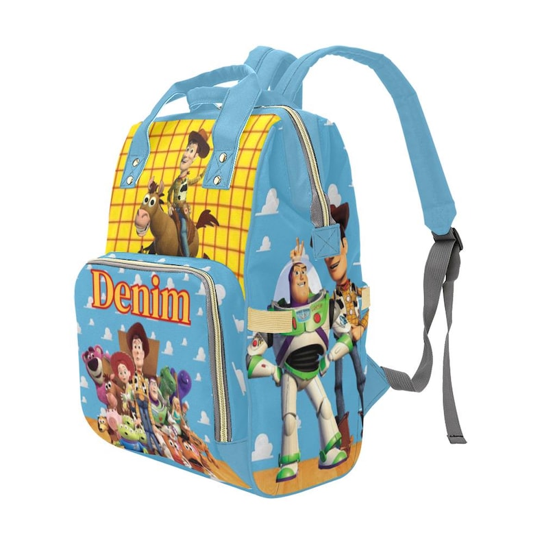 May include: A blue backpack featuring characters from the Toy Story movie. The backpack has a yellow checkered pattern on the top and the word "Denim" on the front pocket. The design includes images of Woody, Buzz Lightyear, and other characters.