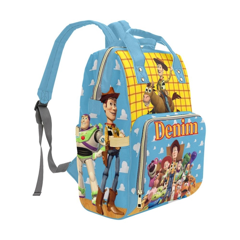 May include: A light blue backpack featuring characters from the Toy Story movie. The backpack has a blue handle and straps, with the word "Denim" printed on the front pocket. The main body of the backpack is light blue with white clouds.