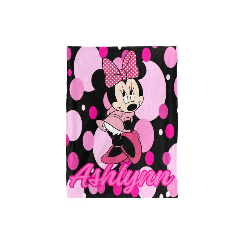 May include: A black blanket with a pink polka dot pattern and a Minnie Mouse graphic. The Minnie Mouse graphic is wearing a pink dress and bow. The name "Ashlynn" is written in pink script at the bottom.