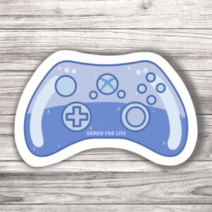 Könnte beinhalten: Ein blauer und weißer Gamer-Controller-Aufkleber mit dem Text "Gamer for Life" darauf.