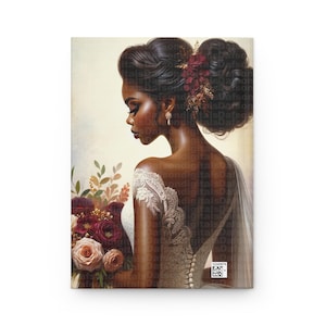May include: A bride with dark skin and a white lace dress holds a bouquet of burgundy and peach roses. Her hair is styled in a bun with a burgundy flower.
