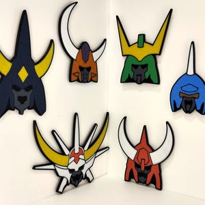 May include: A collection of colorful, stylized helmet-shaped cutouts. The helmets feature various designs with colors like blue, yellow, green, orange, red, and white. They are arranged against a white background, creating a visually striking display.