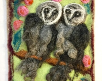 Two owls on a wool painting.