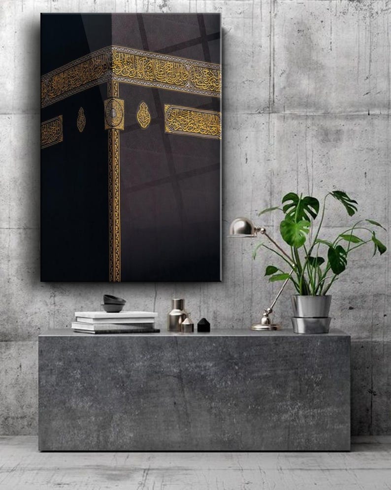 May include: A black and gold framed print of the Kaaba, a cube-shaped building in Mecca, Saudi Arabia. The Kaaba is considered the holiest site in Islam and is a destination for Muslim pilgrims.