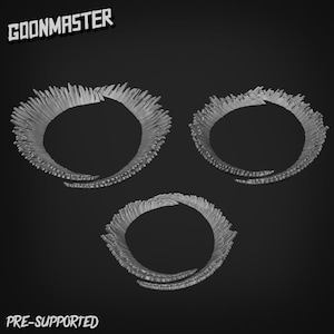 May include: Three gray, ring-shaped objects with a textured, spiky appearance are displayed against a dark background. The text "GOONMASTER" is at the top, and "PRE-SUPPORTED" is at the bottom.