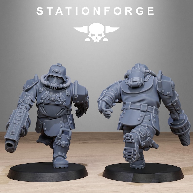 May include: Two gray plastic miniature figures of soldiers wearing futuristic armor and helmets. The figures are posed in a running stance. The figure on the left is holding a large gun. The figure on the right is holding a smaller gun. The figures are standing on black circular bases.