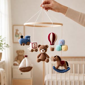 Peut inclure: Un mobile de chambre d'enfant avec un cadre circulaire en bois et des figurines crochetées suspendues, incluant un train bleu, un cube blanc avec le chiffre 1, un ours en peluche marron, une montgolfière rouge et blanche, des cubes alphabet, un voilier et un cheval à bascule.