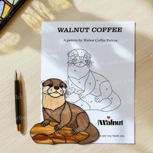 Puede incluir: Un dibujo en blanco y negro de dos nutrias sobre un fondo blanco. Las nutrias est&aacute;n numeradas del 1 al 27. El dibujo se titula "Walnut Coffee" e incluye el texto "A pattern by Walnut Coffee Pattern".