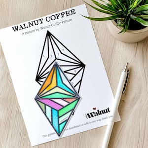 Peut inclure: Un motif géométrique noir et blanc avec des chiffres sur un fond blanc. Un diamant en verre coloré est placé sur le motif. Le texte "Walnut Coffee" et "This pattern... be distributed or sold in any way thank you." est en bas de la page.