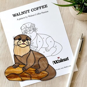Puede incluir: Un patr&oacute;n de vitral de una nutria sentada en una roca. El patr&oacute;n est&aacute; numerado para un proyecto de pintura por n&uacute;meros. El patr&oacute;n se titula "Walnut Coffee" y es un patr&oacute;n de "Walnut Coffee Passion".