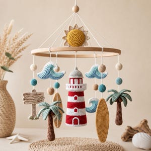 May include: A nautical-themed crochet mobile featuring a central red and white lighthouse, surrounded by hanging elements including a yellow sun, blue waves, palm trees, surfboards, and a signpost, all suspended from a circular wooden frame.