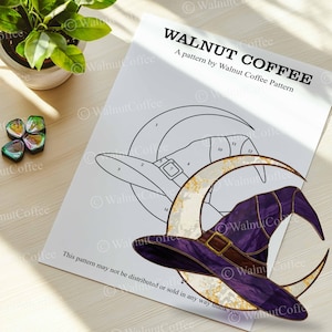 May include: A printed pattern by Walnut Coffee featuring a witch hat and crescent moon design. The hat is purple with a brown band and buckle. The text "WALNUT COFFEE" is at the top of the page.