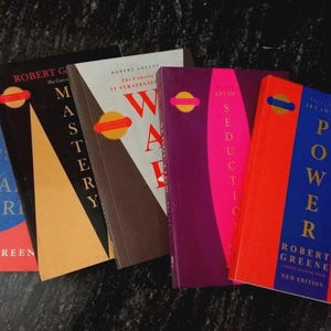 Puede incluir: Una colecci&oacute;n de cinco libros de Robert Greene dispuestos en fila. Los t&iacute;tulos incluyen The Concise Laws of Human Nature, Mastery, The 33 Strategies of War, The Art of Seduction y The 48 Laws of Power, cada uno con colores de portada distintos.