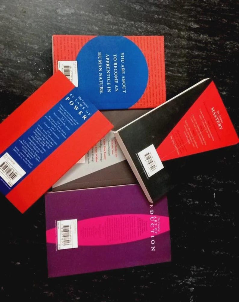 Puede incluir: Cuatro libros con portadas coloridas dispuestos en un grupo. Los libros se titulan The Concise 48 Laws of Power, Mastery y The Art of Seduction. Una portada presenta un c&iacute;rculo azul con el texto You Are About To Become An Apprentice In Human Nature.