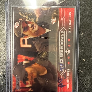 Pode incluir: Carta colecionável com Phil Hellmuth e Mike Matusow. A carta tem um design vermelho e branco com as palavras "Poker Showdowns" e o logotipo Full Tilt Poker. É da série "Razor".