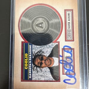 May include: A collectible card featuring a silver record design and a portrait of Coolio. The card includes the text "COOLIO Gangsta's Paradise" and "CERTIFIED SILVER ALBUMS". A blue signature is visible.