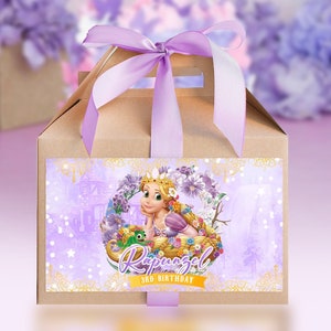 Op de afbeelding: Een bruine kartonnen traktatiebox met een paars lint en een label met Rapunzel uit de Disney-film Rapunzel. Het label heeft een paarse achtergrond met gouden accenten en de tekst "Rapunzel 3rd Birthday".