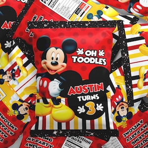 May include: A rectangular snack bag featuring a red background with polka dots, a graphic of Mickey Mouse, and the text OH TOODLES, AUSTIN TURNS 3. The bottom section has yellow, white, and red stripes, while the back displays a nutrition facts label.