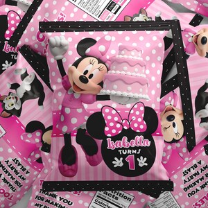 Op de afbeelding: Een roze en wit gestippeld feestzakje met Minnie Mouse die een drielaagse taart vasthoudt. Het zakje toont de tekst Isabella turns 1, Oh Toodles! Thank you for making my party a blast en een voedingswaardelabel met 250 calorieën.