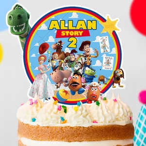 Può includere: Una torta bianca con glassa bianca e codette colorate. La torta è sormontata da un topper rotondo per torta con personaggi del franchise di film Toy Story. Il topper per torta ha uno sfondo blu con il testo "ALLAN STORY 2".