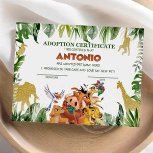 Op de afbeelding: Een rechthoekig adoptiecertificaat met een jungle-thema rand van groene bladeren en gouden glitter dierensilhouetten. De tekst luidt ADOPTION CERTIFICATE, THIS CERTIFIES THAT ANTONIO HAS ADOPTED (PET NAME HERE), I PROMISED TO TAKE CARE AND LOVE MY NEW PET!, SIGNATURE en DATE. Het midden toont kleurrijke stripfiguren, waaronder een leeuwenwelp, een wrattenzwijn, een stokstaartje en een vogel.