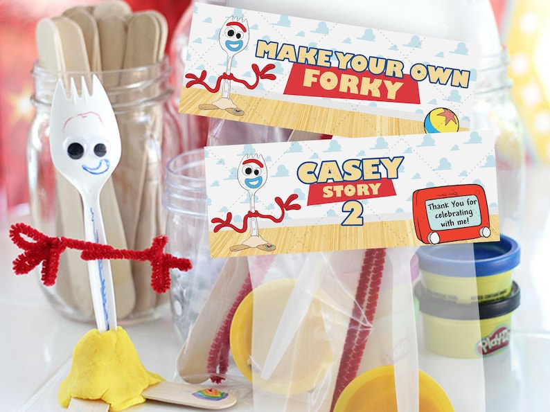 K&ouml;nnte beinhalten: Eine wei&szlig;e Plastikgabel, die in einen Forky-Charakter verwandelt wurde, mit roten Pfeifenreinigerarmen und einer gelben Basis. Zwei Karten lesen "Make Your Own Forky" und "Casey Story 2". Weitere Bastelmaterialien sind sichtbar.