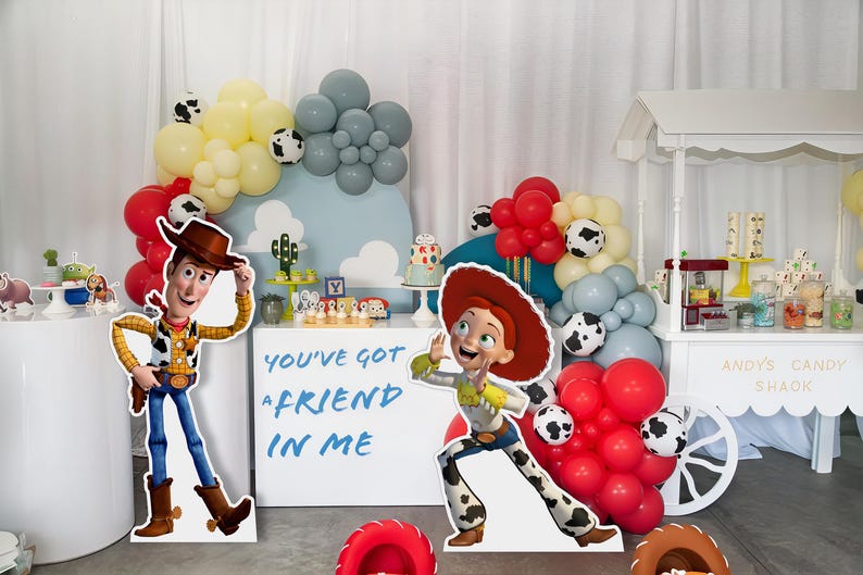 May include: A Toy Story themed party with a white candy cart, balloons, and cardboard cutouts of Woody and Jessie. The cart has the text "Andy's Candy Shack" on the side. The cardboard cutouts have the text "You've got a friend in me".