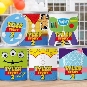 Puede incluir: Seis latas de favor de fiesta con el tema de Toy Story 2 con diferentes personajes. Las latas están decoradas con imágenes de Woody, Buzz Lightyear, Alien, Jessie y Bo Peep. Cada lata tiene el texto "Tyler Story 2" en ella.