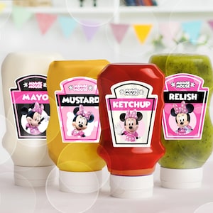 Könnte beinhalten: Vier Kunststoff-Quetschflaschen für Gewürze mit Minnie-Mouse-Etiketten. Die Flaschen enthalten weiße Mayonnaise, gelben Senf, roten Ketchup und grünes Relish. Jedes Etikett zeigt den Namen der Figur und die jeweilige Sorte in fetter Schrift.