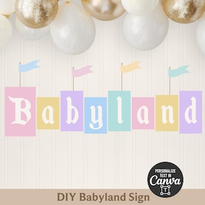 May include: A decorative sign featuring the word Babyland in white letters on colorful rectangular blocks, each topped with a small flag. The design is accented by a cluster of white and gold balloons at the top and a Canva personalization icon.