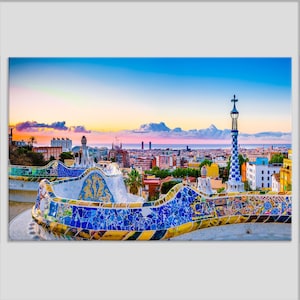 May include: A colorful mosaic bench with a view of the Barcelona skyline at sunset. The bench is decorated with blue, yellow, and green tiles. The city skyline is in the background, with the Mediterranean Sea in the distance.