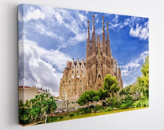 May include: A view of the Sagrada Família basilica in Barcelona, Spain. The basilica is a large, ornate church with a distinctive facade and multiple towers. The church is surrounded by trees and a pond.