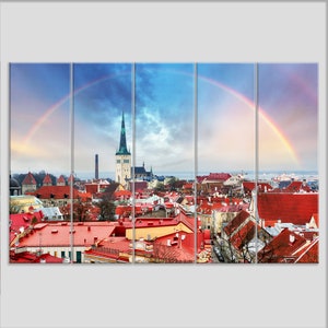 May include: A panoramic view of a city with red rooftops and a tall church steeple. A rainbow arches over the city, creating a colorful and vibrant scene.