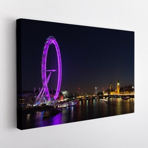 May include: A night-time view of the London Eye Ferris wheel lit up in purple, with the Houses of Parliament and Big Ben in the background. The River Thames flows in the foreground.
