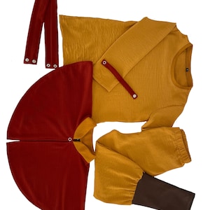 Puede incluir: Una camisa de manga larga color amarillo mostaza con una tira de bot&oacute;n a presi&oacute;n, una capa rojo oscuro con cuello y cierre a presi&oacute;n, un pantal&oacute;n amarillo mostaza con pu&ntilde;os marr&oacute;n oscuro y dos tiras de tela rojo oscuro con botones a presi&oacute;n.