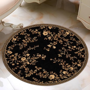 May include: A round black rug with a floral design. The rug features a border and a pattern of beige flowers and leaves. The rug is placed on a marble floor, and is near furniture.