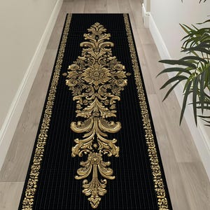 Può includere: Un lungo tappeto rettangolare nero con un motivo floreale dorato. Il tappeto presenta un medaglione floreale dorato centrale e bordi dorati. Lo sfondo è nero con linee a puntini bianche verticali. Questo tappeto decorativo è adatto ai corridoi.