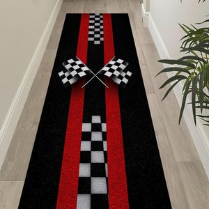 May include: Black runner rug with red racing stripes and checkered flag design. The rug features a central checkered pattern and two crossed checkered flags, creating a race track theme. The rug is designed for a hallway or entryway.