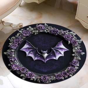 Puede incluir: Una alfombra redonda, de color morado y negro, con un borde decorativo de rosas moradas y un murci&eacute;lago negro en el centro. El murci&eacute;lago tiene un cuerpo y alas de color morado oscuro con una cara blanca.