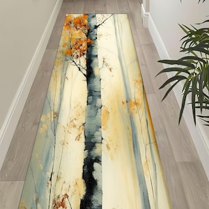 May include: A rectangular runner rug featuring a painted forest scene with birch trees and autumn foliage. The color palette includes shades of yellow, orange, gray, and black. The rug is designed to fit a hallway or entryway.