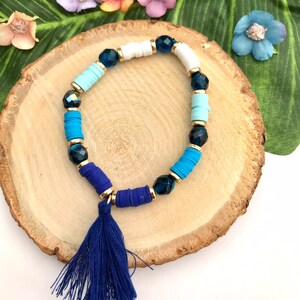 Bracelet bleu avec perles et pompon montés sur élastique