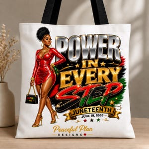 May include: White tote bag with black handles featuring a woman in a red dress and the words "POWER IN EVERY STEP" in silver and gold. The bag also includes the word "Juneteenth" and the date "June 19, 1865".