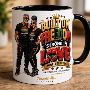 May include: White ceramic mug with a black interior and handle. The mug features a graphic of a couple and the words "Built on Freedom, Strong in Love, Juneteenth 1865." Additional text includes "Our History. Our Love. Our Legacy."