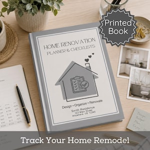 May include: A gray home renovation planner and checklist book with the text "Home Renovation Planner & Checklists." The cover features a house graphic and the text "Design, Organize, Renovate." The book is on a wooden surface.